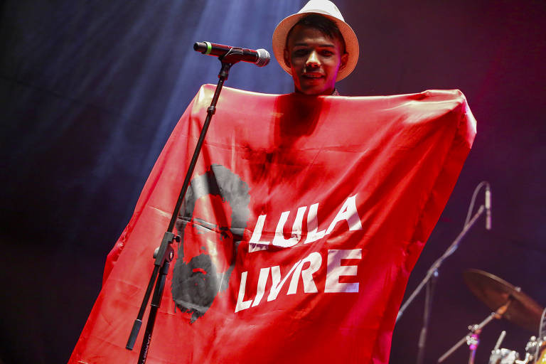 Mestre Anderson Miguel segura bandeira de 'Lula Livre' no festival Radioca 2019, na Chácara Baluarte, em Salvador (Rafael Passos - 10.nov.2019/Divulgação)